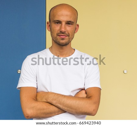 Portrait of young bald tanned man close up
