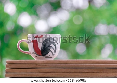 Coffee cup on the bokeh tree background with a picture of lifestyle.