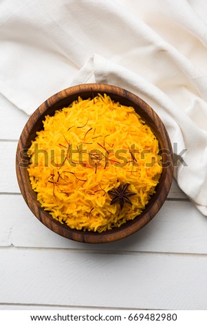 Saffron rice or Kesar chawal / bhat, served in a white ceramic bowl, selective focus Royalty-Free Stock Photo #669482980