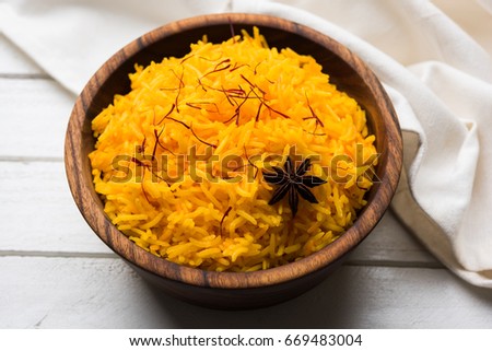 Saffron rice or Kesar chawal / bhat, served in a white ceramic bowl, selective focus Royalty-Free Stock Photo #669483004