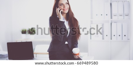Smiling businesswoman talking on the phone at the office