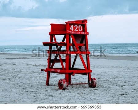 Red lifeguard chair on a deserted beach.