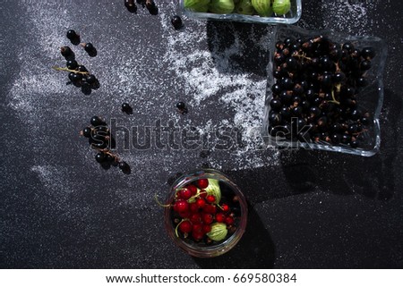 Summer fresh berries still life on a black background in a dish