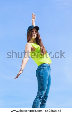 Portrait of pretty casual carefree teenager girl in cap relaxing outdoor. Urban street fashion and freedom concept.