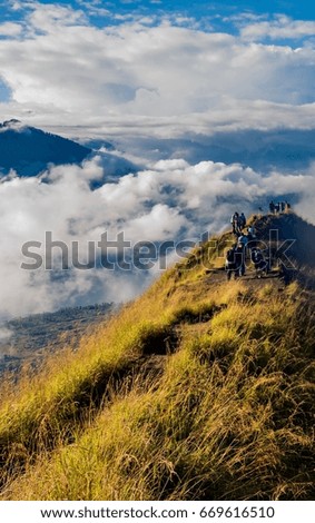 hikers with backpacks standing on top of the mountain enjoying valley view and taking a pictures