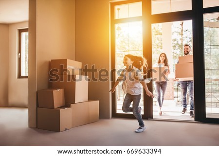 Happy family with cardboard boxes in new house at moving day. Royalty-Free Stock Photo #669633394