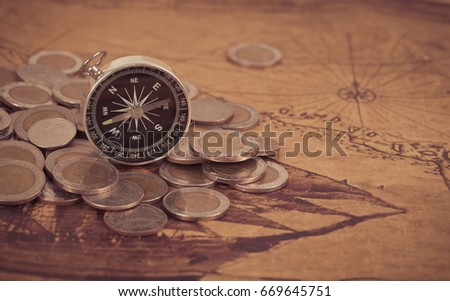 compass with old coin on old map