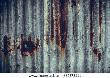 Old rusty corrugated tin zinc metal wall in vintage tone with vignetting.