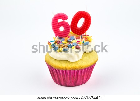 Cupcake with number sixty - 60 - pink candles with white vanilla frosting and colour star sprinkles in pink paper case isolated on white background - female birthday background with space for text