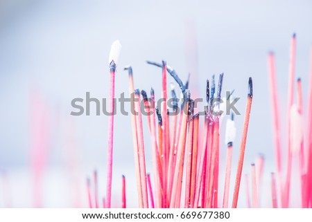 Close up of burning incense sticks with smoke for background