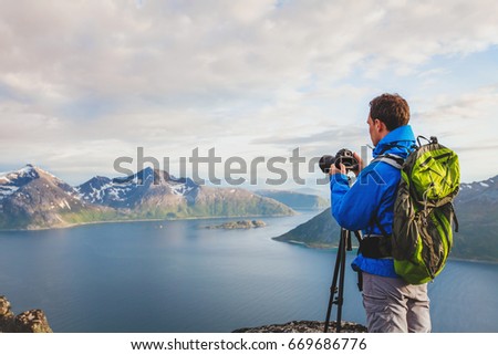 professional landscape and nature photographer with tripod outdoors, travel to Norway
