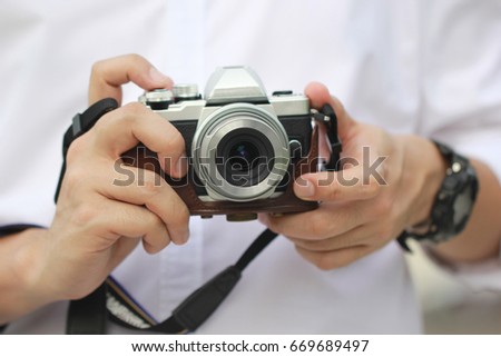 Photographer holding mirrorless camera Royalty-Free Stock Photo #669689497