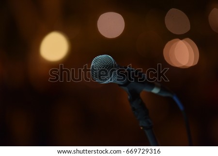 Close up of microphone of a DJ over the abstract blurred background on a big wedding party.