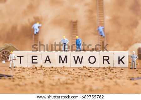 A conceptual photo of workers and a word, which represents teamwork.