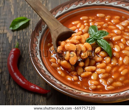 Beans in tomato in a dish on a wooden background Royalty-Free Stock Photo #669757120