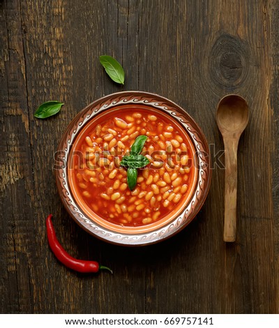 Beans in tomato in a dish on a wooden background Royalty-Free Stock Photo #669757141