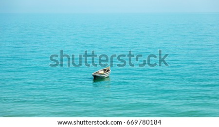 Beautiful idyllic seascape with boat. gentle soft beautiful picture of sea landscape of calm sea with an old fishing boat. Seascape with an old boat on quiet wave. Soft focus. High key