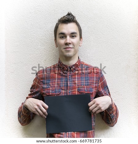 Young man holding poster
