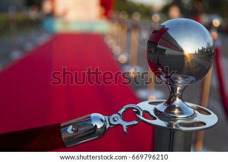 Long red carpet between rope barriers on VIP entrance. Royalty-Free Stock Photo #669796210