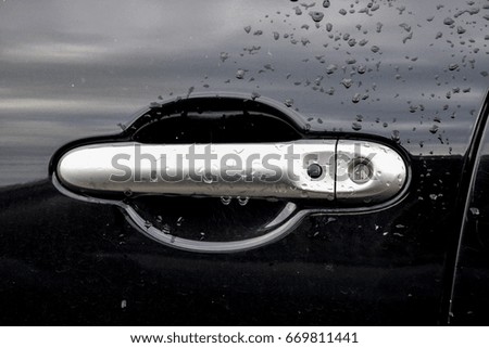 Water droplets on the handle of a black car