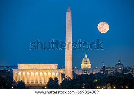Supermoon above three iconic monuments: Lincoln Memorial, Washington Monument and Capitol Building in Washington DC as viewed from Arlington, Virginia