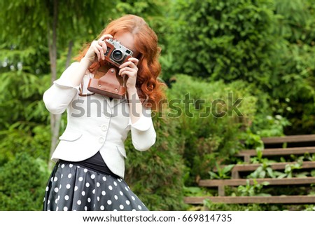 Woman with an old vintage camera in the park