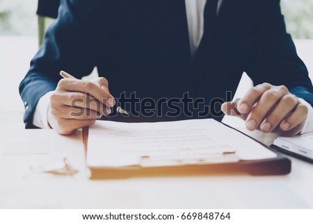 Hand holding pen for signature, business