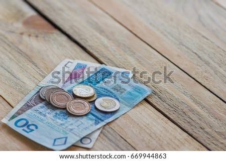 Polish zloty on the old wooden background, soft focus background