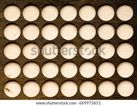 Wooden texture with a pattern of many round holes background