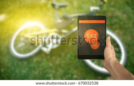 hand with tablet and bicycle 