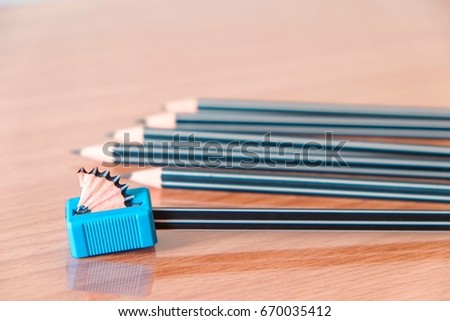 Close up sharpening shaving on wooden table with pencils