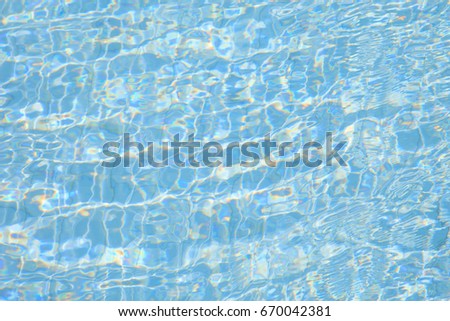 Blue pool water background with water ripple texture on a bright and sunny day.