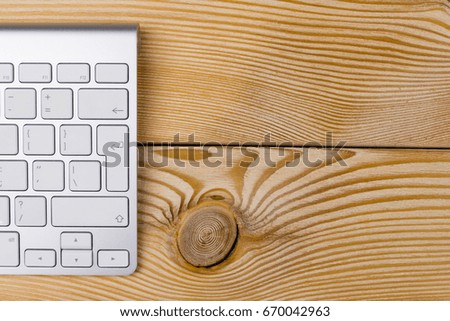 Business workplace with wireless keyboard on old natural wooden table background. Office desk with copy space