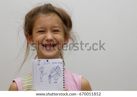 Little girl writing "I Love my mom". gray background