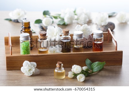 Essential oils,sea salt, stones and jasmine blossom on wooden tray