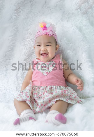 Portrait of cute asian baby in pink dress on carpet wool,happy baby concept,smile