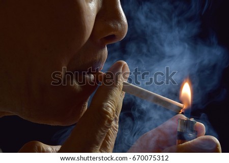 A man lighting a cigarette with a lighter