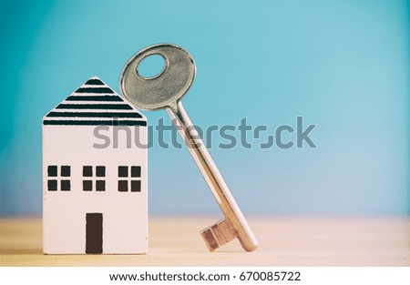 small house model with key over wooden floor. selective focus. Filtered image