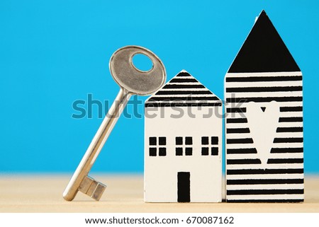 small house model with key over wooden floor. selective focus.