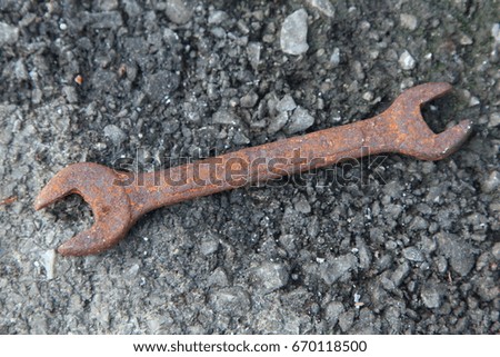 Close up of Old Rusty Wrench over a wooden background