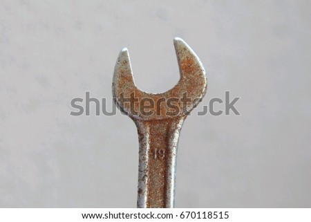 Close up of Old Rusty Wrench over a gray blur background