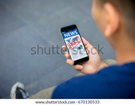 Fake news,Hoax concept.close-up of Hipster man hands holding mobile phones Royalty-Free Stock Photo #670130533