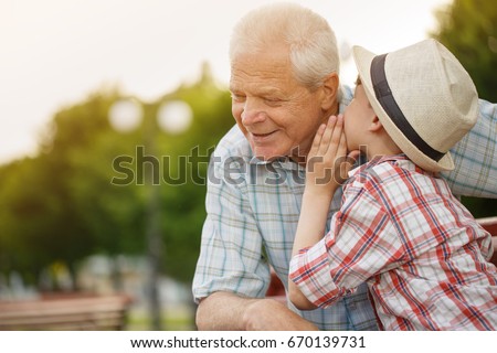 Shot of a cute little boy whispering something to his grandfather while resting together outdoors copyspace family communication relationships trust happiness love gossip children kids parenting Royalty-Free Stock Photo #670139731
