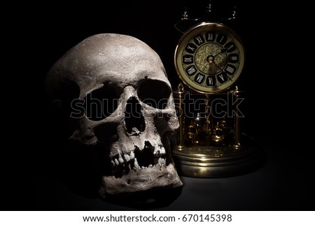Human skull with vintage clock close up on black background