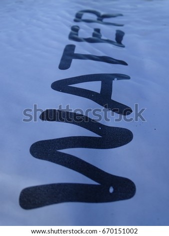 In the photo is a sheet of paper on which it is written "Water". Paper is photographed under the water. Photo was made on the river Isar near Vorderriss (upper Bavaria, Germany).