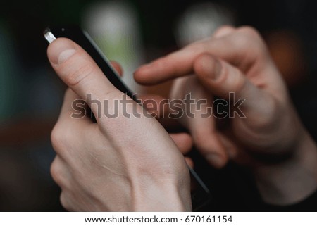 Close-up of mans hands holding mobile phone. Macro shot.