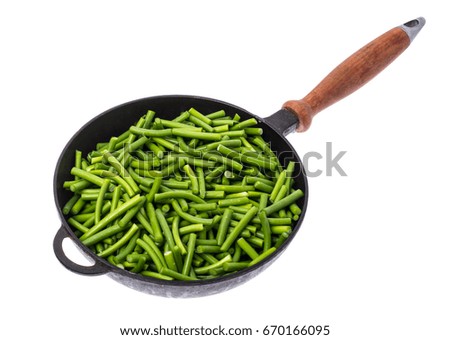 Cut into pieces of green beans in frying pan on white background. Studio Photo