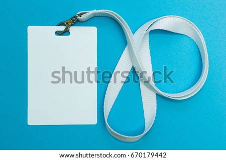 Blank badge mockup isolated on blue. Plain empty name tag with string.
