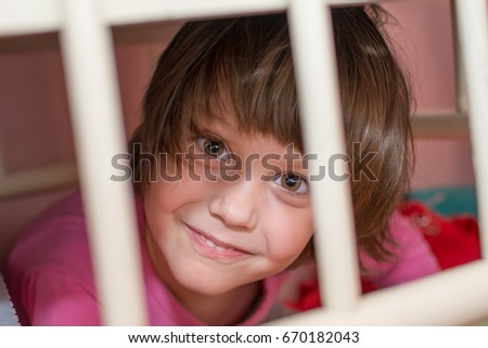 Child behind bars of the crib