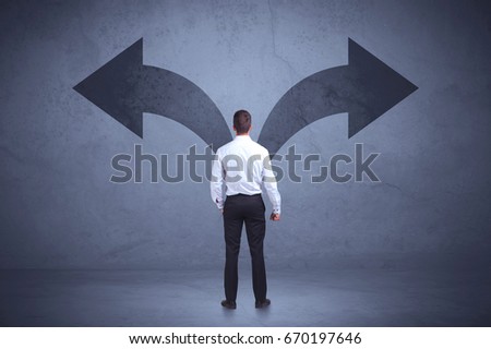 Businessman taking a decision while looking at arrows on the wall concept background